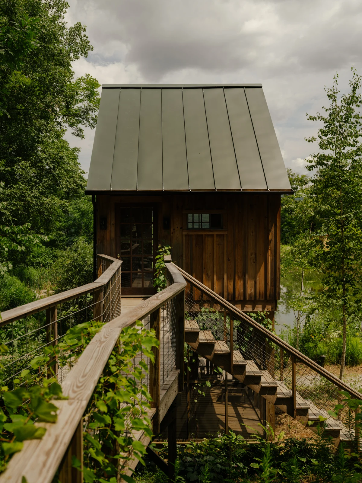 The elevated walkway leads to the tree house entrance.