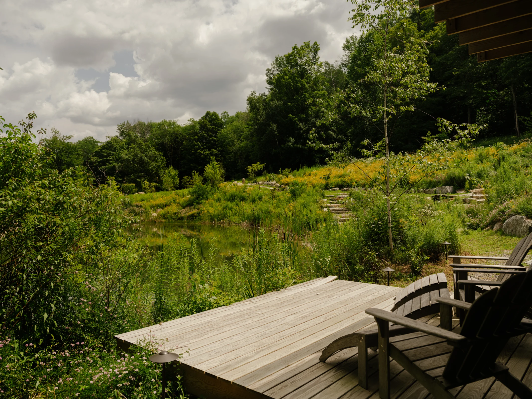 The deck at the tree house offers a place to relax, take in views across the pond, and watch wildlife among the surrounding plantings.