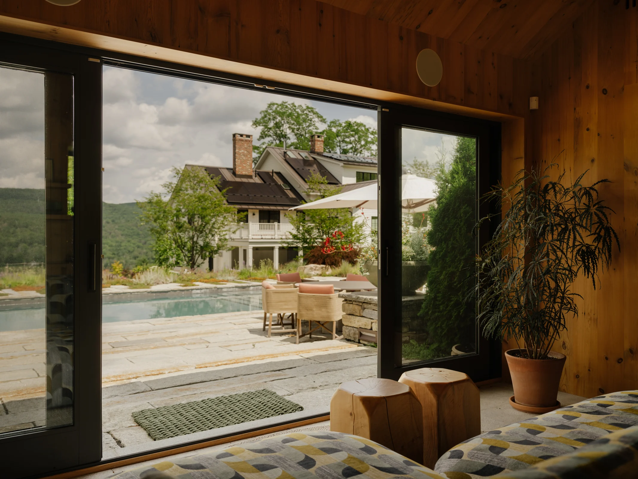 View from inside the pool house toward the terrace seating area and pool