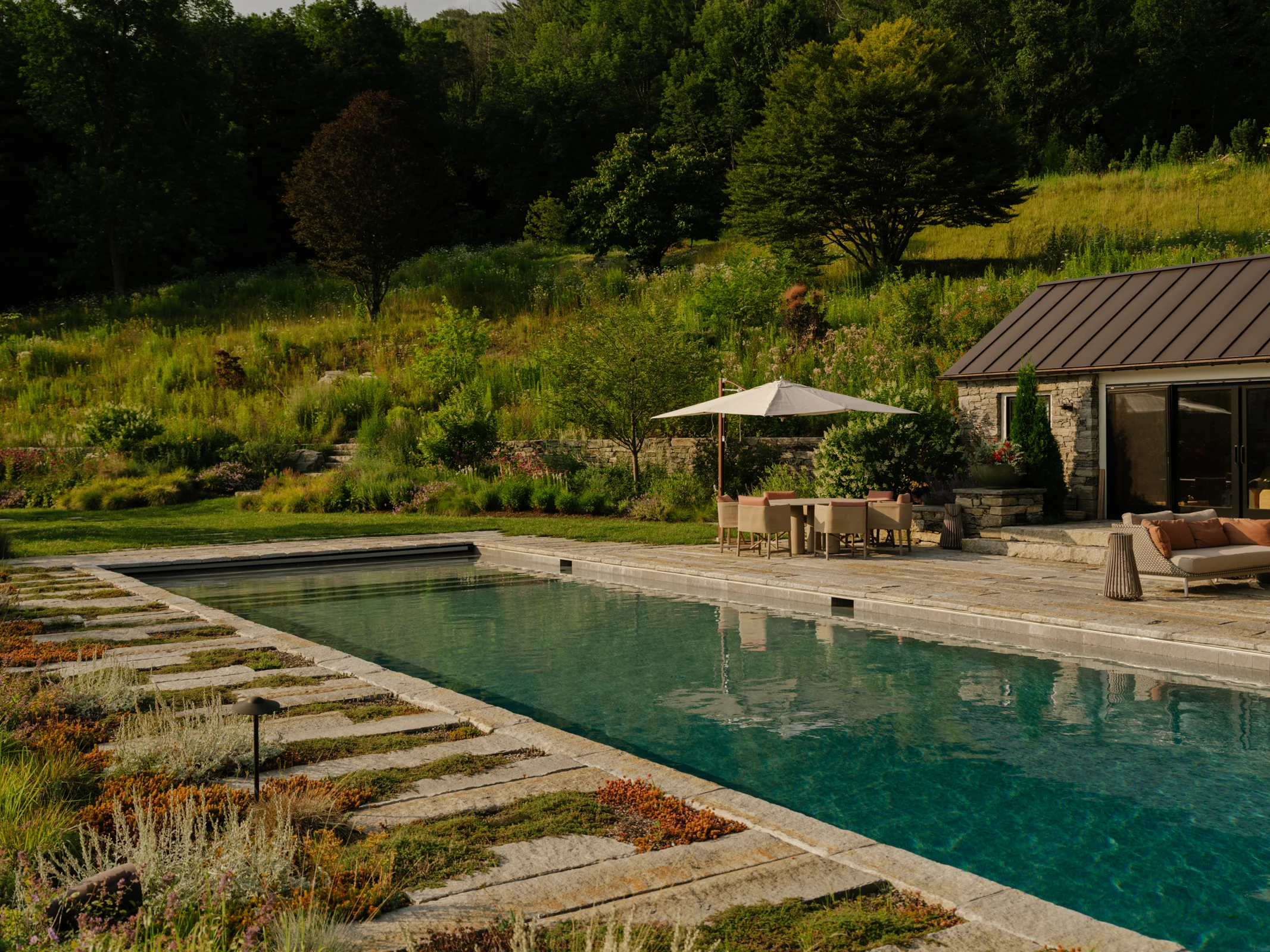 Stone steppers and low groundcovers keep views open while spending time in the pool.